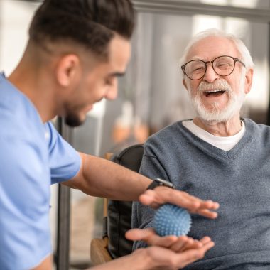 Patient having his hand massaged with a spiky massage ball