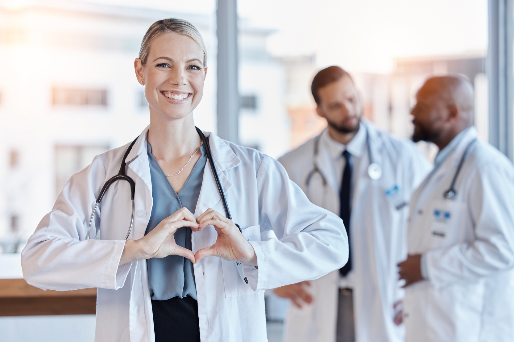 Healthcare, heart and hands with portrait of doctor in hospital for medical, support and kindness. Motivation, wellness and medicine with woman and gesture in clinic for cardiology, care and emoji.