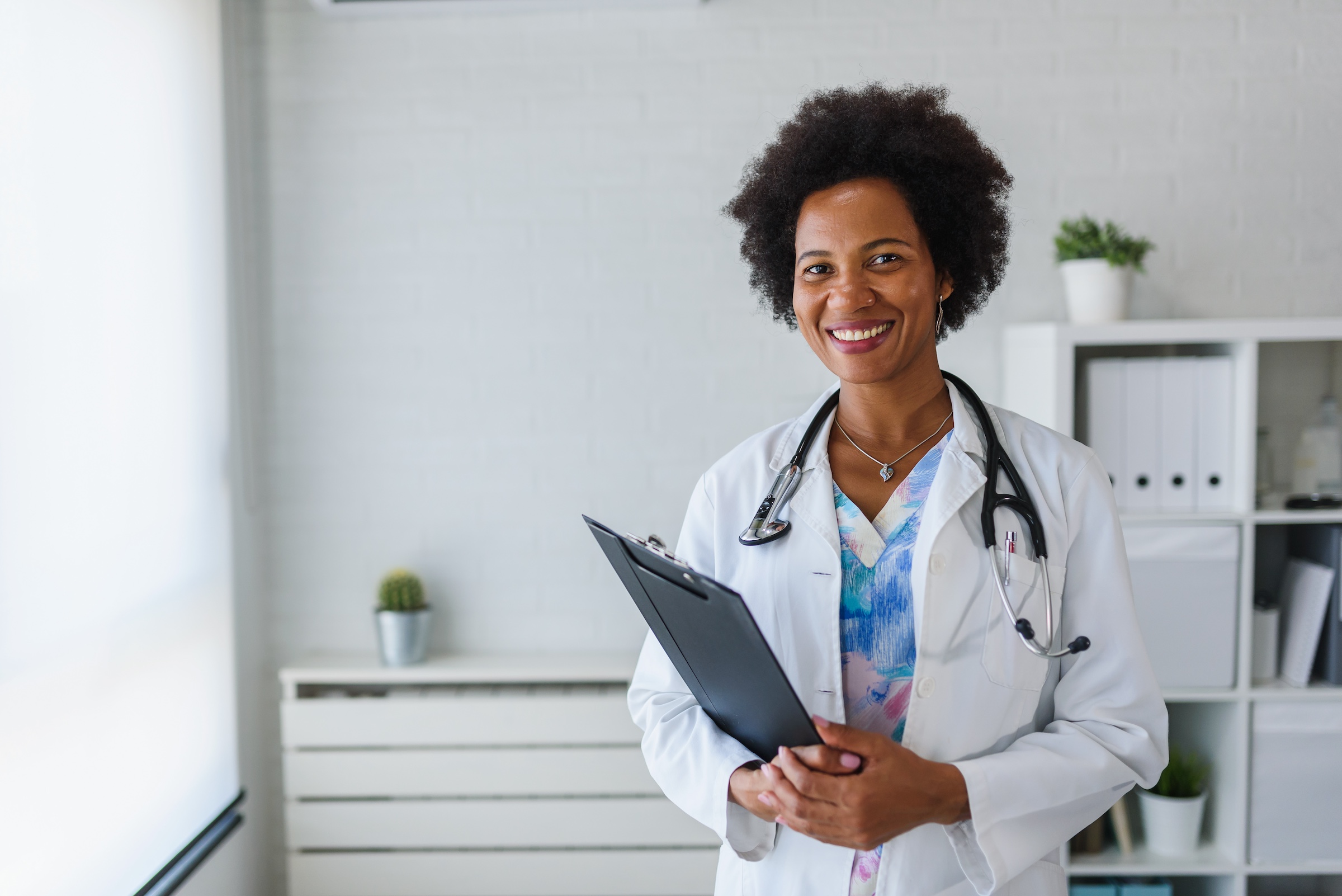 Portrait of female African American doctor standing in her office at clinic