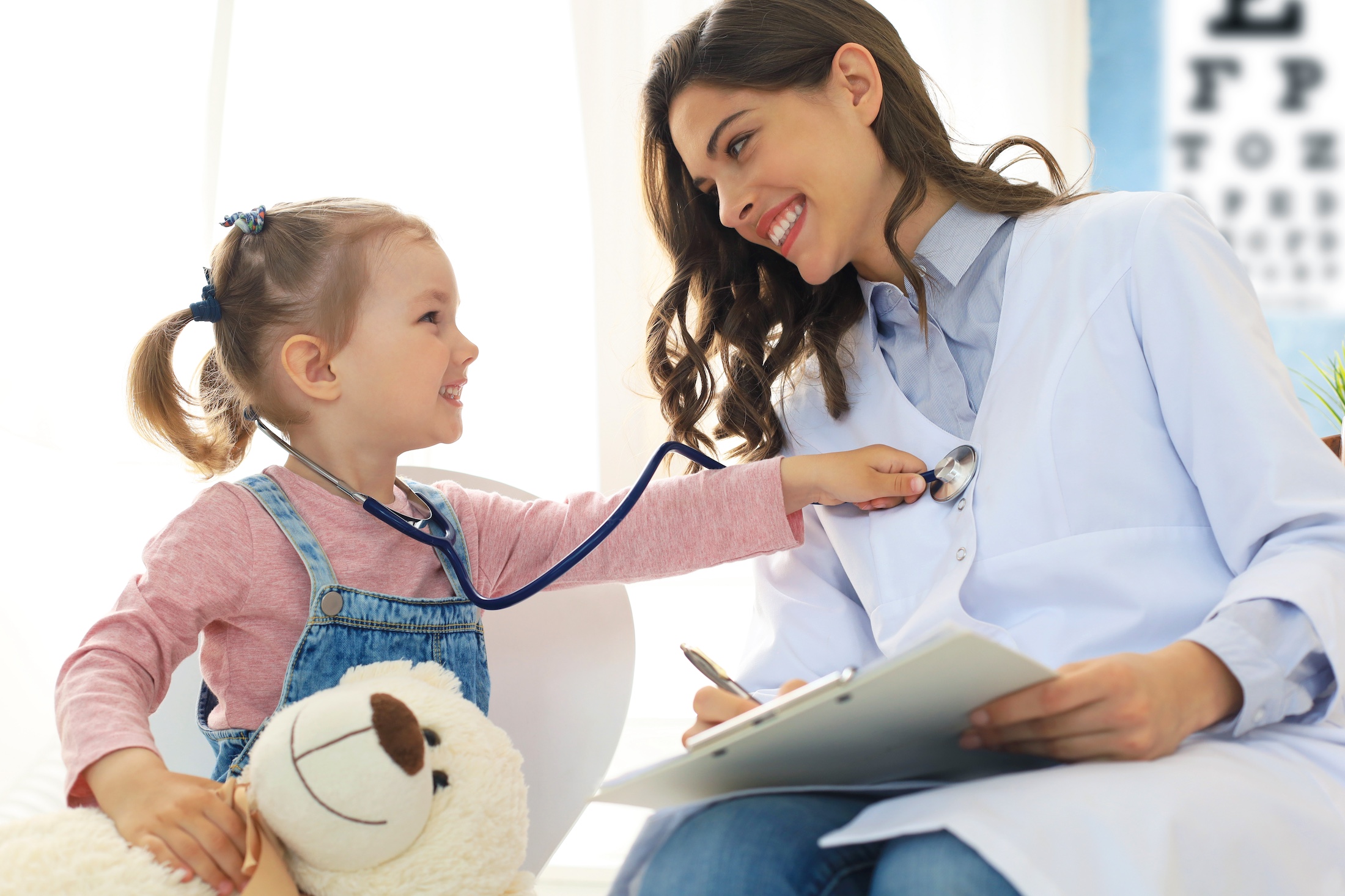 Little girl at the doctor for a checkup. Child auscultate the heartbeat of the doctor