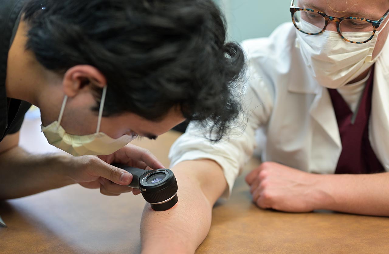 A student listens to a pulse of an instructor